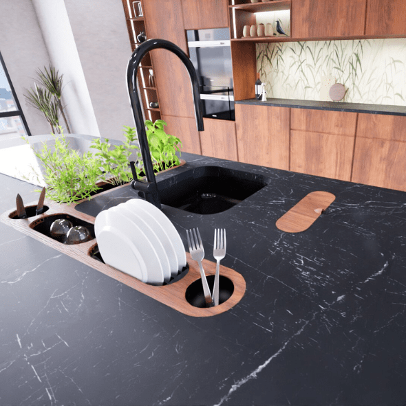 Untitled design (22) Modern kitchen with a black marble island featuring a built-in sink, dish rack, utensils holder, and a small herb garden; wooden cabinets and green plant backsplash in the background.